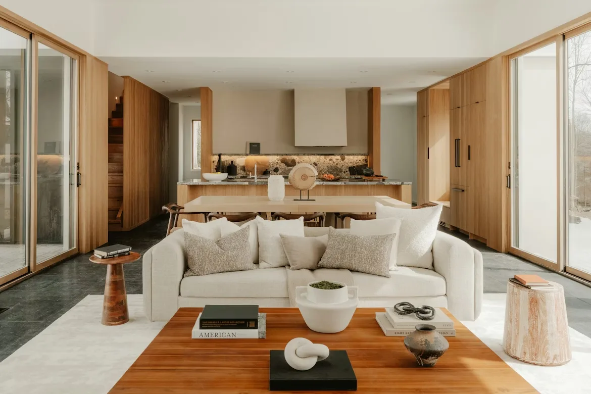 Timber-lined living room with a sofa and open kitchen