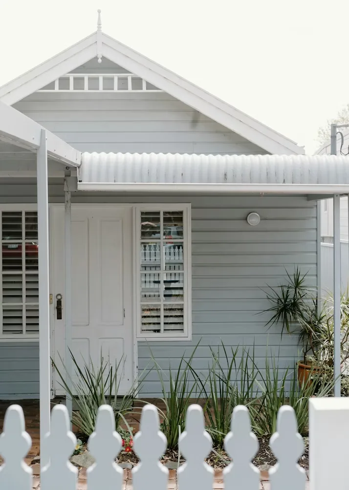 Weatherboard cottage with a white picket fence